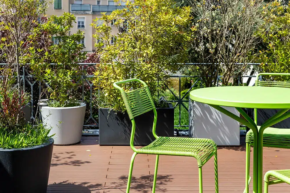 Aménagement toit terrasse avec bacs et pots noir et blanc et mobilier de couleur